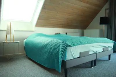 a bedroom with a large bed with a wooden ceiling at Villa Nida in Ranum
