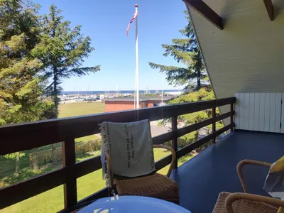 a chair on a balcony with a view of the ocean at Villa Nida in Ranum
