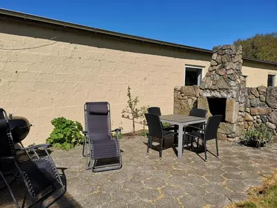 a patio with a table and chairs and a stone fireplace at Værelse som dobbelt el. enkelt, Engen 5, 7770 Vestervig in Vestervig