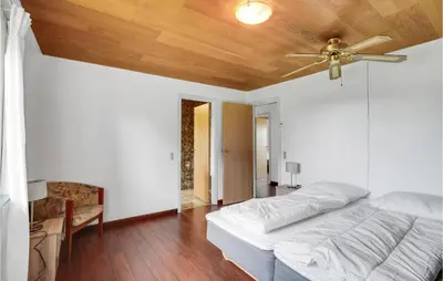 a bedroom with a ceiling fan and a bed at Gorgeous Home In Hanstholm With Kitchen in Hanstholm