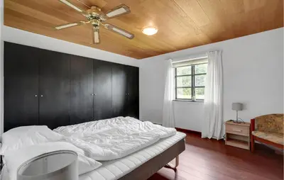 a bedroom with a bed with a ceiling fan at Gorgeous Home In Hanstholm With Kitchen in Hanstholm