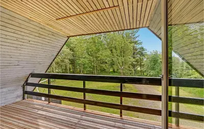 a screened in porch with a view of the woods at Cozy Home In Øster Assels With Sauna in Øster Assels