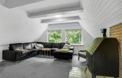 a living room with a couch and a table at Cozy Home In Øster Assels With Sauna in Øster Assels