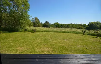 a large field of grass with a wooden bench at Gorgeous Home In Fjerritslev in Fjerritslev