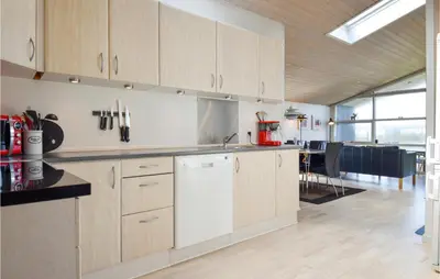 a kitchen with white cabinets and a dining room at Gorgeous Home In Harboøre With Wifi in Harboør