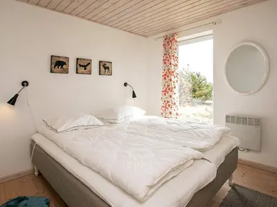 a bedroom with a large white bed with a window at Luxury Dunes Retreat-By Traum in Pandrup