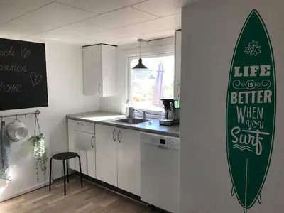 a kitchen with a surfboard on the wall at Seaside VØ in Nørre Vorupør