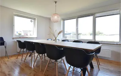 a dining room with a large wooden table and chairs at Awesome Home In Harboøre With Kitchen in Harboør