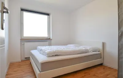 a bed sitting in a room with a window at Awesome Home In Harboøre With Kitchen in Harboør
