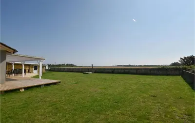 a large yard with a deck and a fence at Awesome Home In Harboøre With Kitchen in Harboør