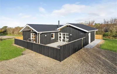 a small house with a black roof at Awesome Home In Vestervig With Sauna in Vestervig