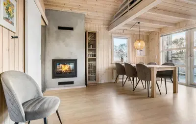 a dining room with a table and chairs and a fireplace at Awesome Home In Vestervig With Sauna in Vestervig