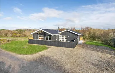 a small black house on a gravel road at Awesome Home In Vestervig With Sauna in Vestervig