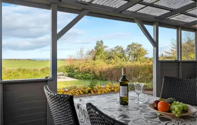 a table with a bottle of wine and a bowl of fruit at Cozy Home In Vinderup With Wifi in Vinderup