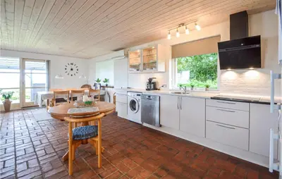 a kitchen with white cabinets and a table in it at Cozy Home In Vinderup With Wifi in Vinderup