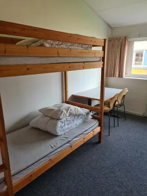 a bedroom with a bunk bed and a desk at Stoholm Vandrehjem in Stoholm