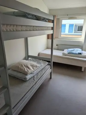 two bunk beds in a room with a window at Stoholm Vandrehjem in Stoholm