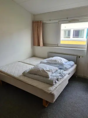 a bed in a small room with a window at Stoholm Vandrehjem in Stoholm