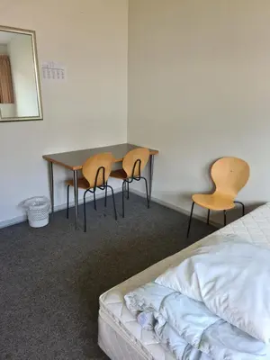 a bedroom with a table and two chairs and a bed at Stoholm Vandrehjem in Stoholm