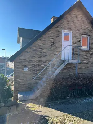 a brick building with a staircase leading to a door at Holiday Home Penthouse Lemvig in Lemvig