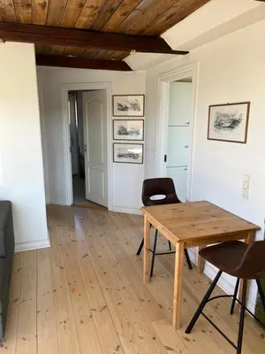a dining room with a wooden table and chairs at Holiday Home Penthouse Lemvig in Lemvig
