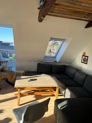 a living room with a couch and a table at Holiday Home Penthouse Lemvig in Lemvig