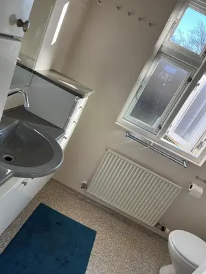 a bathroom with a toilet and a sink and a window at Holiday Home Penthouse Lemvig in Lemvig