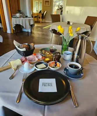 a table with a plate of breakfast food on it at Hotel Phønix in Holstebro