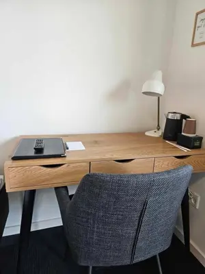a wooden desk with a laptop and a chair at Hotel Phønix in Holstebro