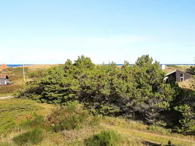 a house on a hill with trees in a field at Charming Beach Retreat - By Traum Ferienwohnungen in Fjerritslev