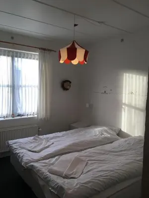 a white bed in a bedroom with a chandelier at Roslev Hus in Roslev