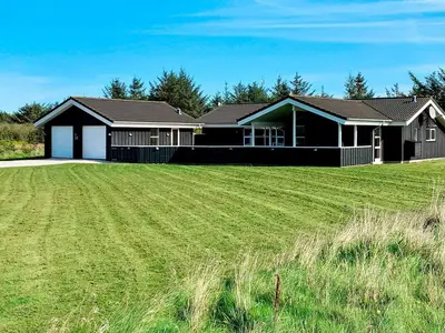 a house with a large grass field in front of it at Luxury Retreat in Gronhoj-By Traum in Løkken