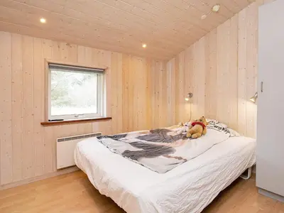 a bedroom with a bed with a teddy bear on it at Luxury Retreat in Gronhoj-By Traum in Løkken
