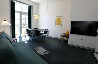 a living room with a couch and a table and a tv at Hotel Steenbergs in Nykøbing Mors