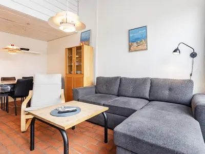 a living room with a couch and a table at Cozy Cottage in Skaven Strand-By Traum in Brovst