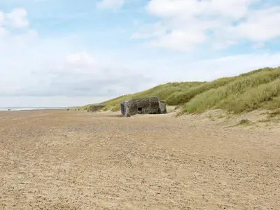 an object sitting on a sandy beach next to a hill at Cozy Cottage in Skaven Strand-By Traum in Brovst