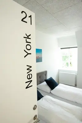 a bedroom with two beds and a sign that says percent at Hotelcity in Holstebro