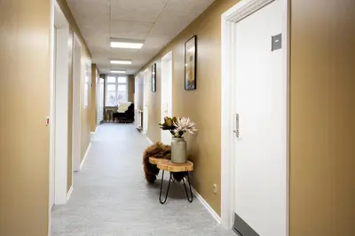 a hallway of an office with a vase on a table at Hotelcity in Holstebro
