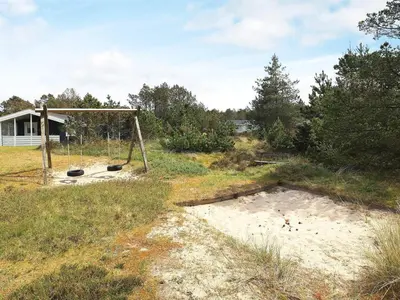 an old swing set in the middle of a field at Bright Coastal Retreat in Vorupor-By Traum in Thisted