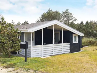 a small black house with a white porch at Bright Coastal Retreat in Vorupor-By Traum in Thisted