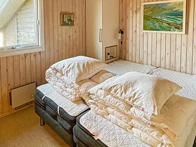two twin beds in a room with a window at 6 person holiday home in Løkken in Løkken