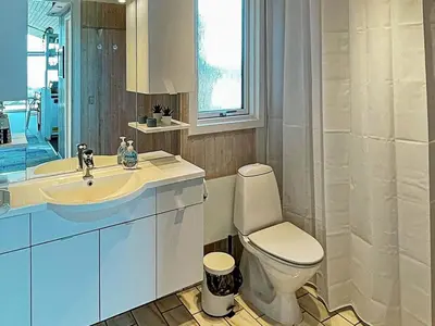 a white bathroom with a toilet and a sink at 6 person holiday home in Løkken in Løkken