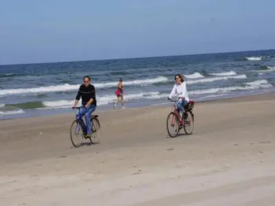 two people riding bikes on the beach at 8 person holiday home in Blokhus in Blokhus