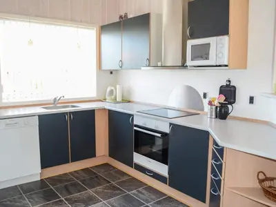 a kitchen with blue cabinets and a sink at 6 person holiday home in Løkken in Løkken