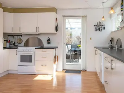 a kitchen with white cabinets and a counter top at Secluded Forest Haven-By Traum in Løgsted