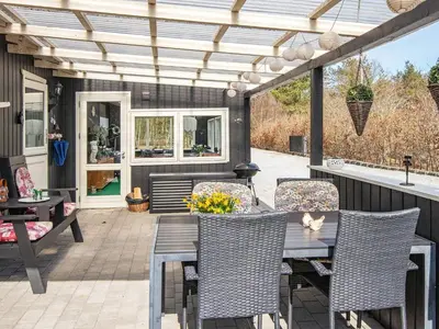 a patio with a wooden pergola and a table and chairs at Secluded Forest Haven-By Traum in Løgsted