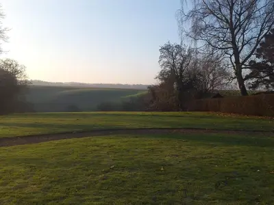 a field of grass with a tree in the distance at 6 person holiday home in Roslev in Roslev