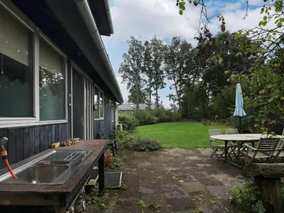 a patio with a sink and a table and an umbrella at 6 person holiday home in Roslev in Roslev