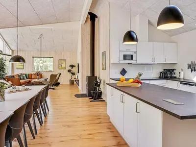 an open kitchen and living room with white cabinets at 18 person holiday home in Fjerritslev in Fjerritslev