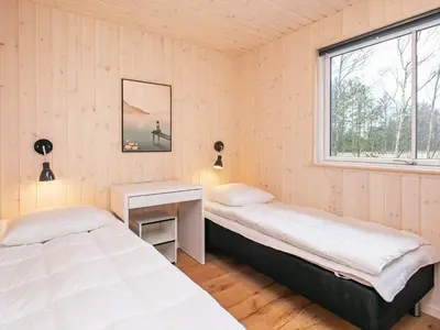 a bedroom with two beds and a desk and a window at 18 person holiday home in Fjerritslev in Fjerritslev